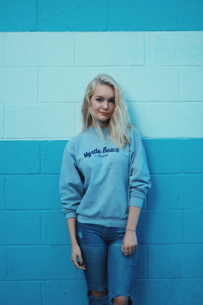 woman in teal sweater and blue jeans